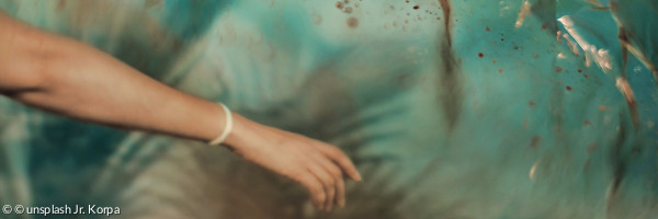 Unterarm mit Hand vor wasserähnlichem Hintergrunf